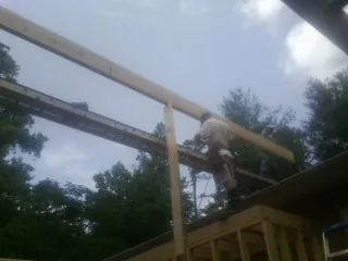 Carpenter setting a ridge beam over a new addition frame — Ice Dam Removal by Roofing Brothers in Whippany