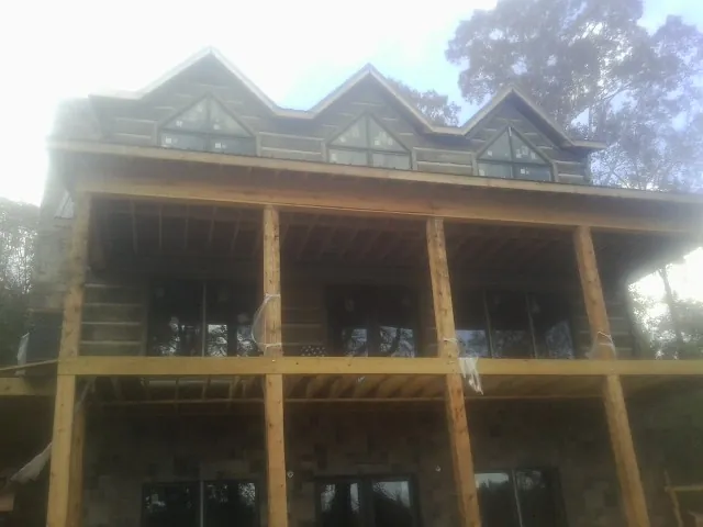 Dormers and porch framing on a large log home under construction — Roof Coating work by our crew in Whippany