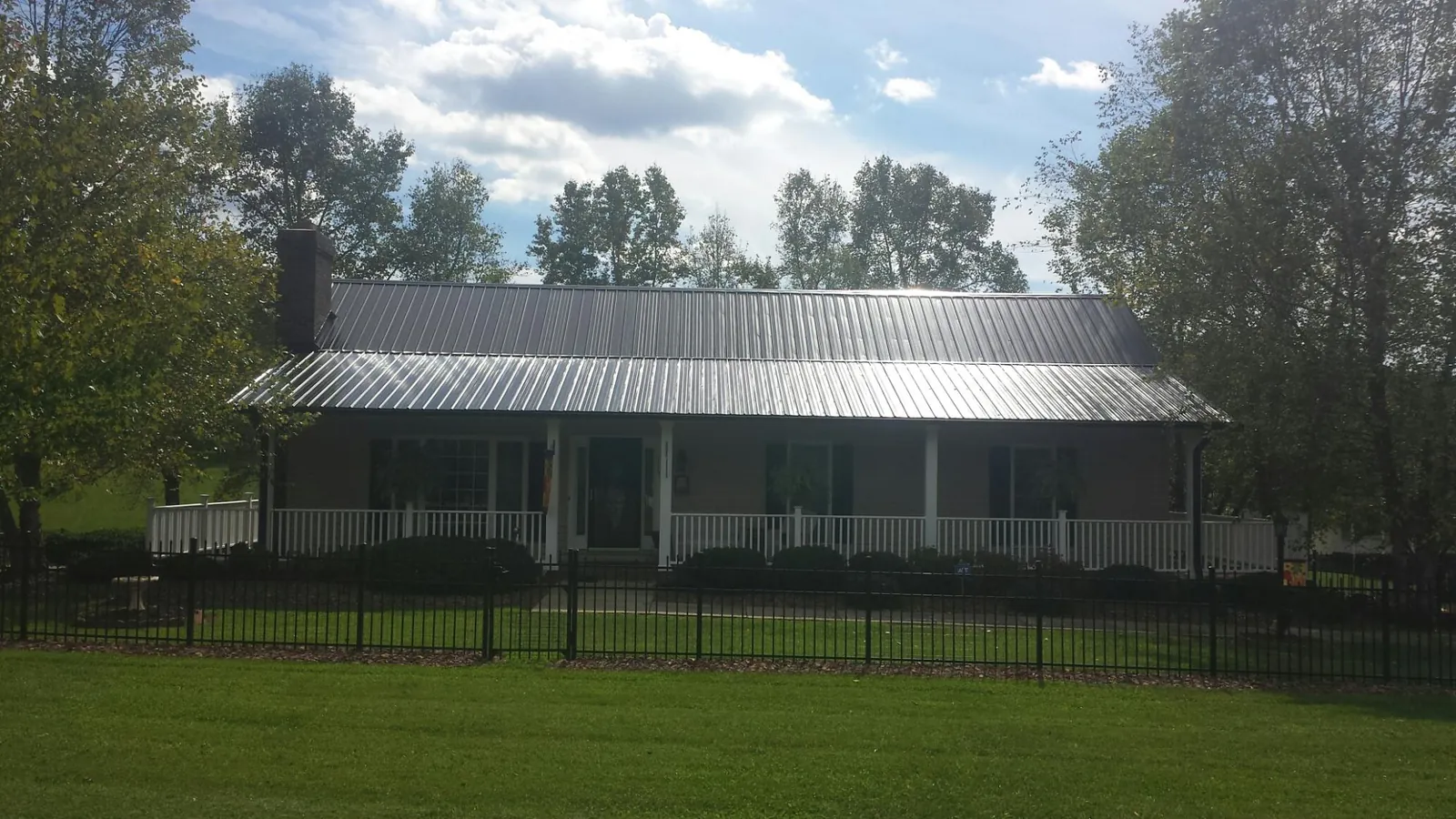 Gray metal roof on a brick ranch with a full width front porch — Gutter Guard Installation work by our crew in Whippany